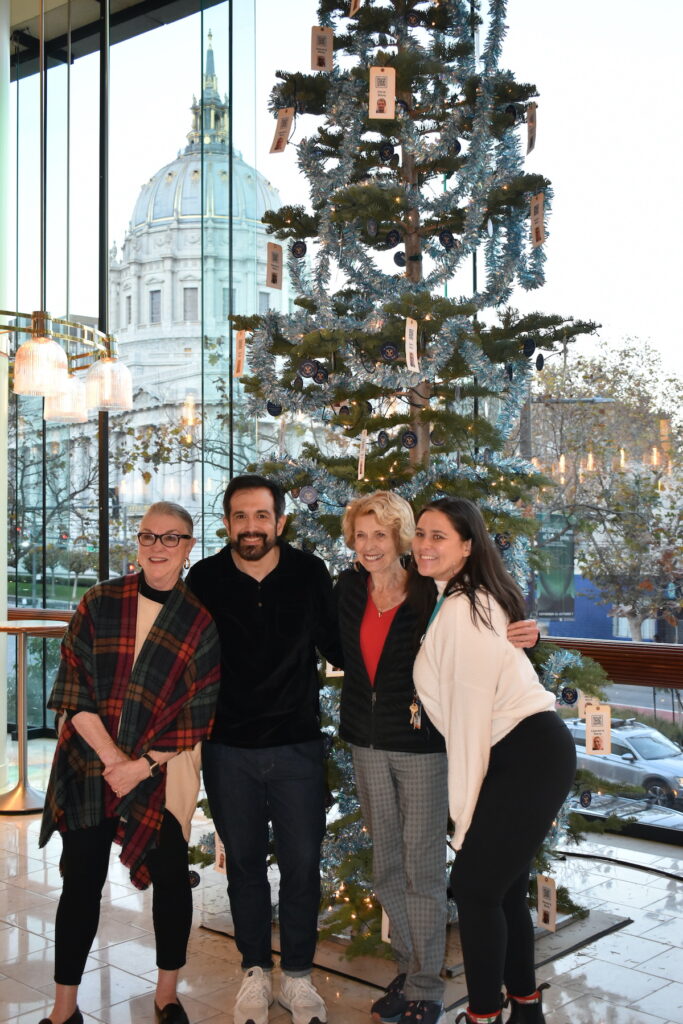 Staff and volunteers pose in front of St. Anthony's tree at Davies Symphony Hall