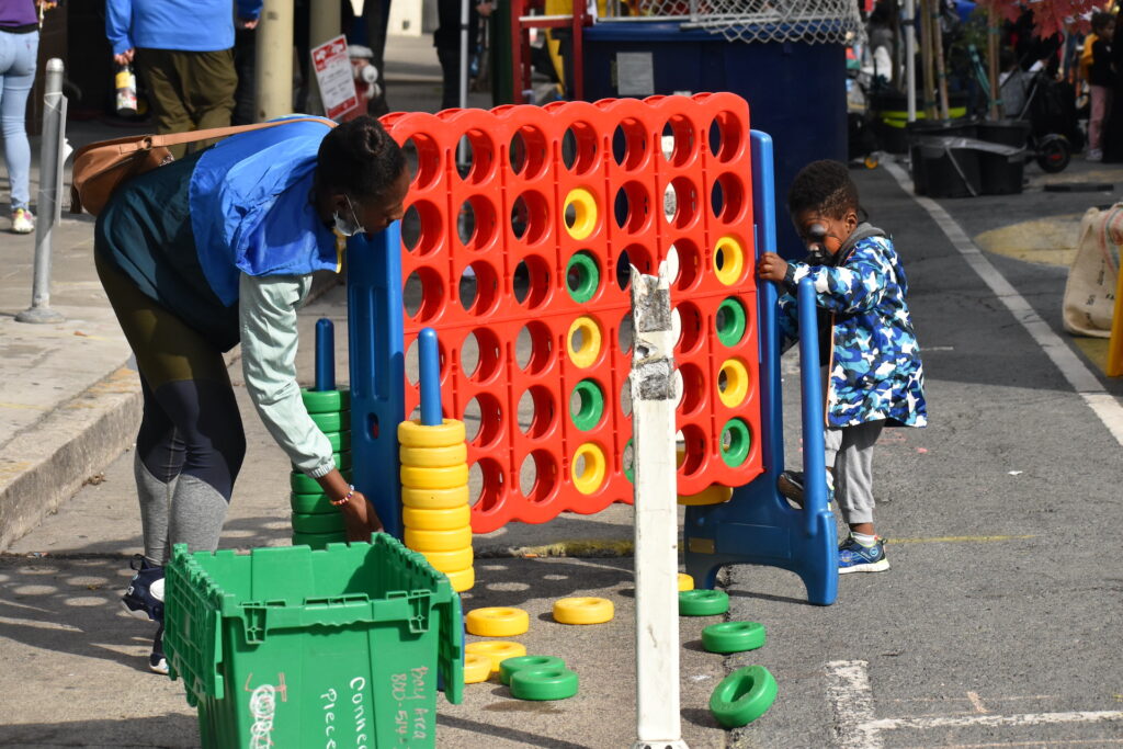 A mother and son play giant connect four on Golden Gate Ave during Phoenix Day in San Francisco 