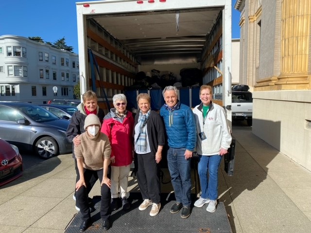 St. Ignatius parishioners pose in front of loaded truck filled with Free Clothing Program donations