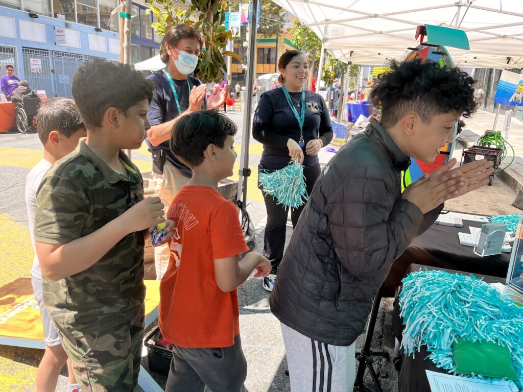 Kids line up to play games at the St. Anthony's Sunday Streets Booth