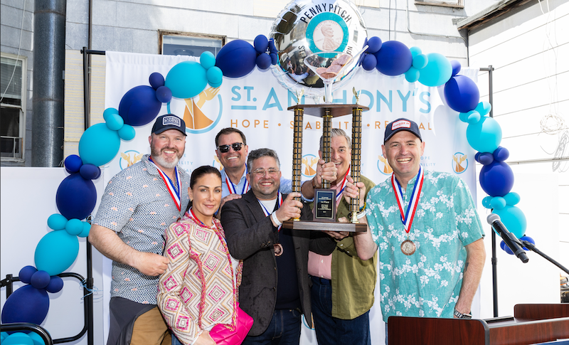 The winning team holds the first place trophy at the 4th Annual Penny Pitch